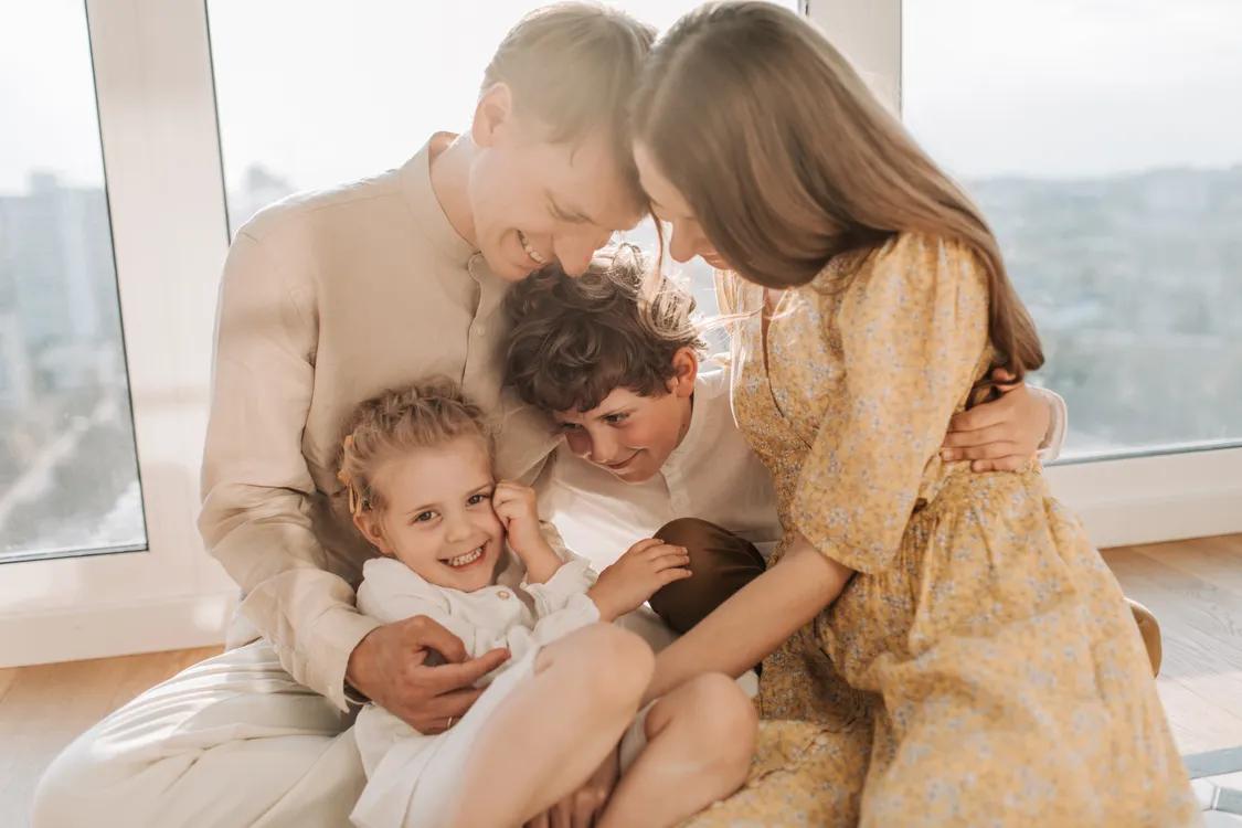 Familia sonriendo en casa con su asesora de seguros de salud — plantilla VITALCARE
